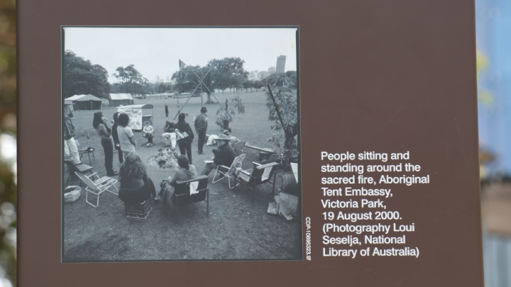 A council sign at the campsite displays a photo of the Aboriginal Tent Embassy Sydney in 2000